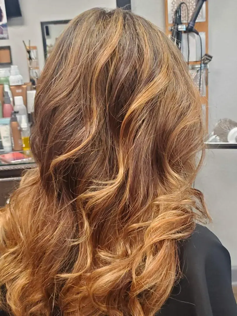 A woman with long brown hair is looking at the camera.