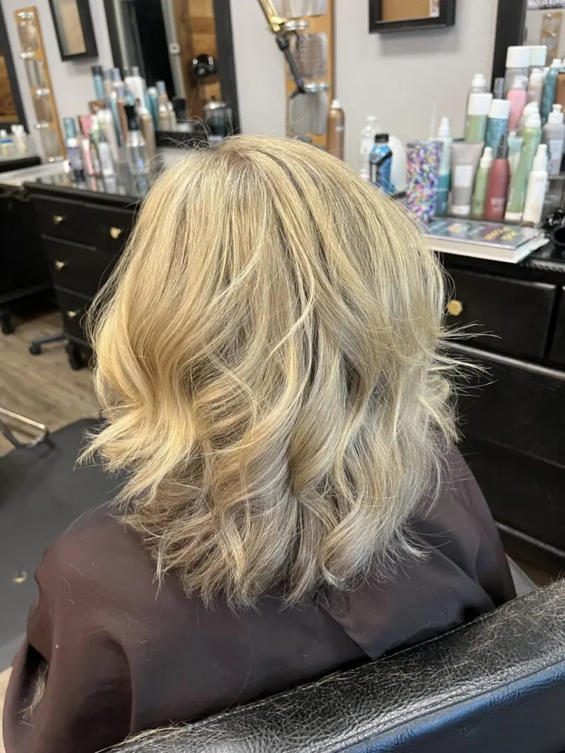 A woman sitting in front of some hair dresser.